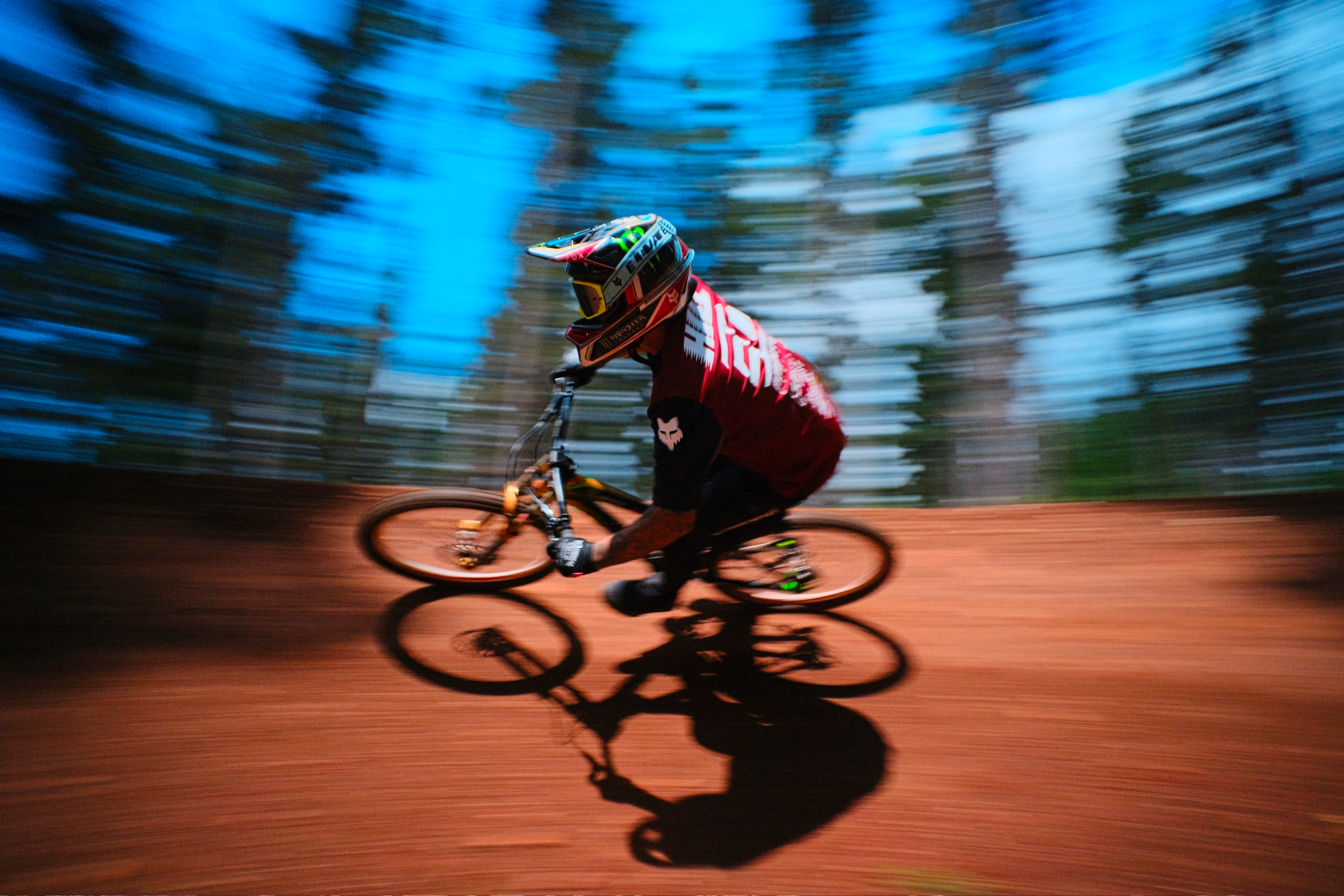 Biker in action on a trail with trees in the background